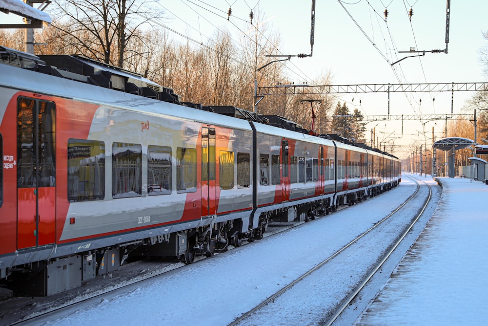 a red and white train traveling down train tracks