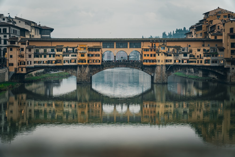 a bridge over a body of water with buildings in the background