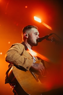 a man with a beard playing a guitar