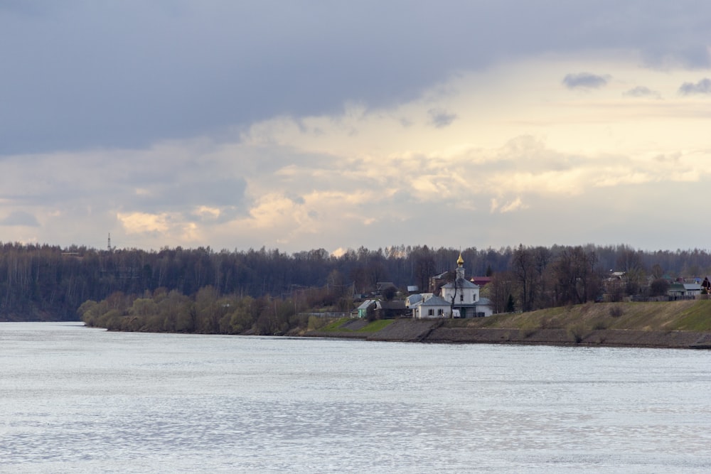 a body of water with houses on a hill in the background