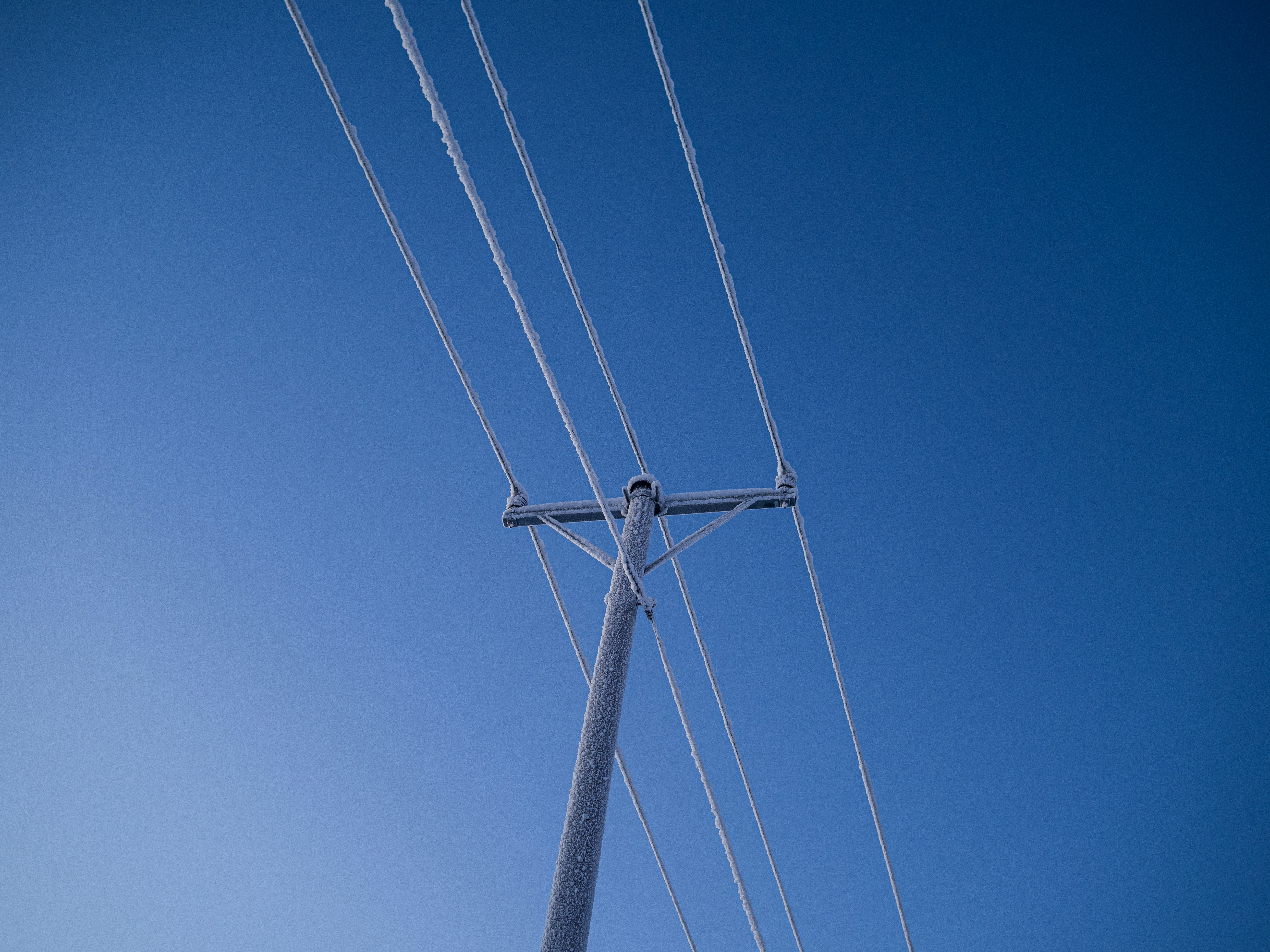 a telephone pole with a blue sky in the background