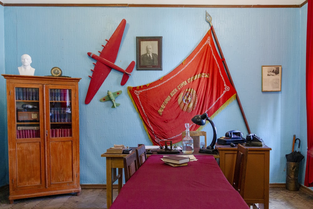 a room with a red table cloth and a red plane on the wall