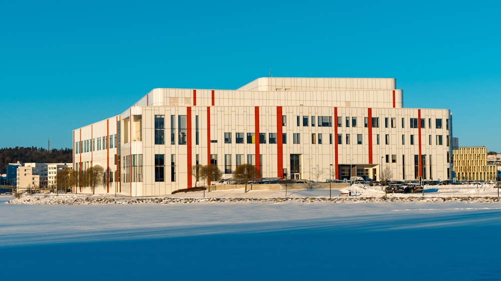 a large building with a lot of windows in the middle of a snowy field