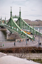 a green bridge with a train going over it