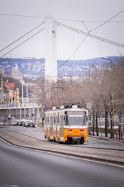 a yellow and white bus driving down a street