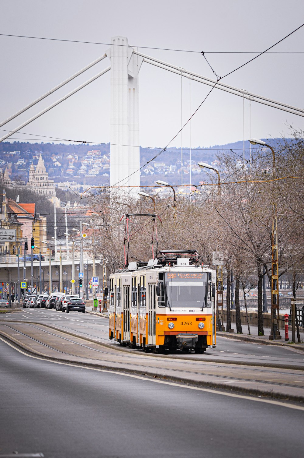 a yellow and white bus driving down a street