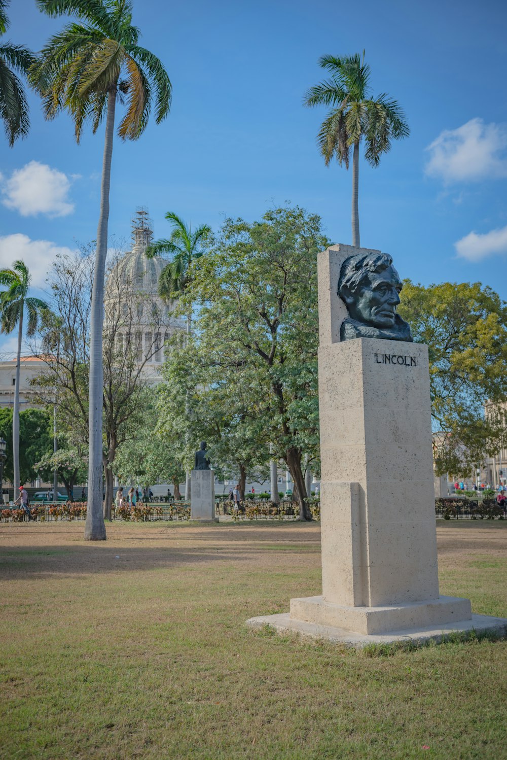 un monument dans un parc avec des palmiers en arrière-plan