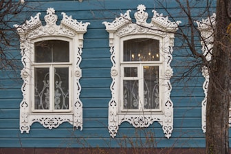 a blue building with two windows and a clock