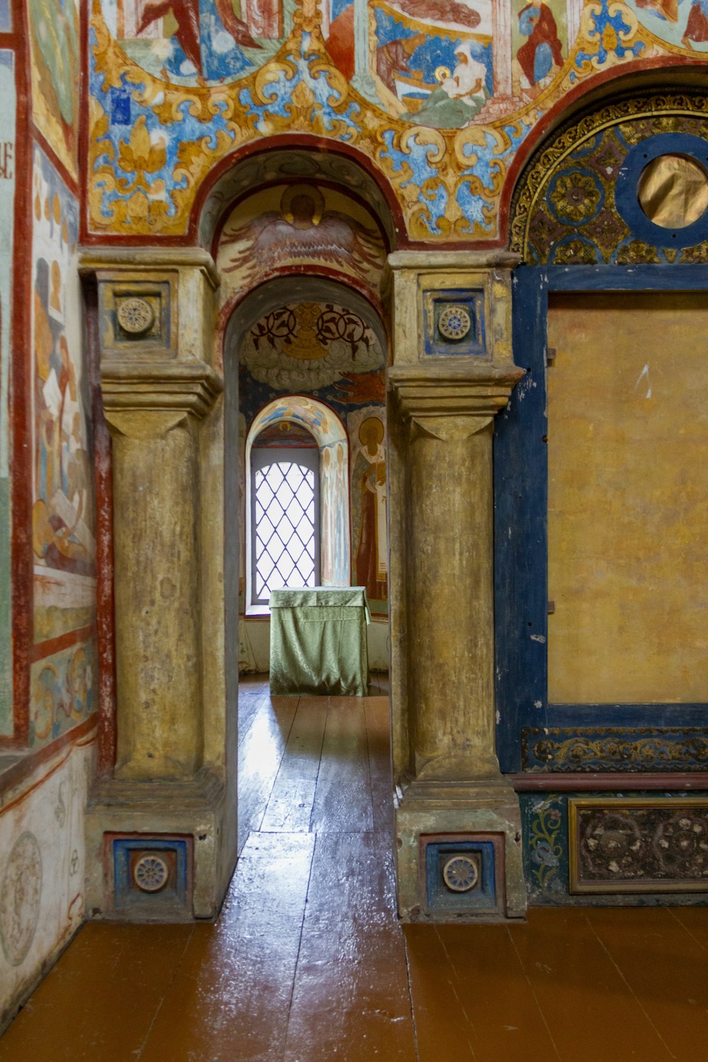 a room with a painted ceiling and a wooden floor