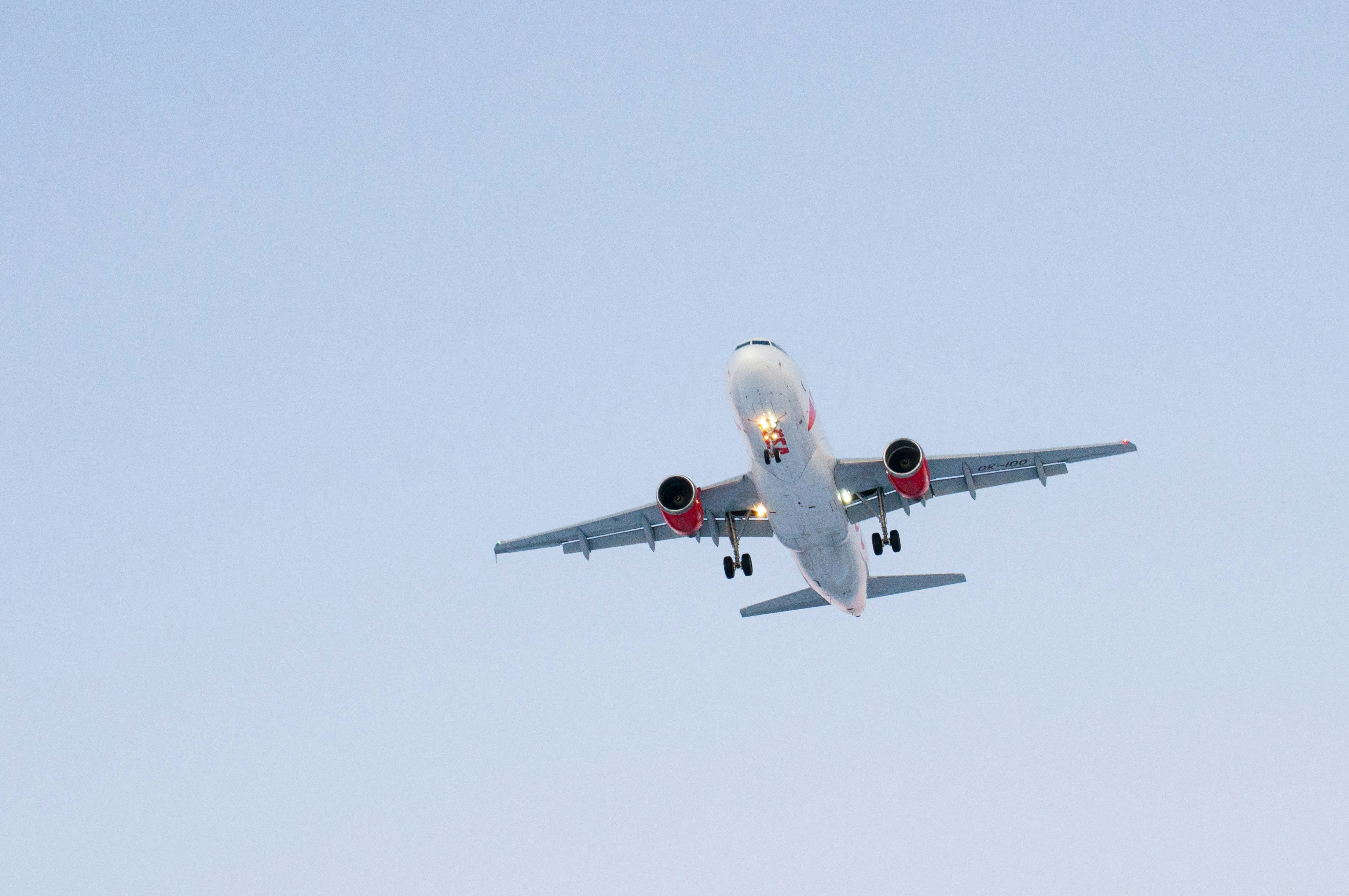 a large jetliner flying through a blue sky, OK-IOO landing at Prague Airport