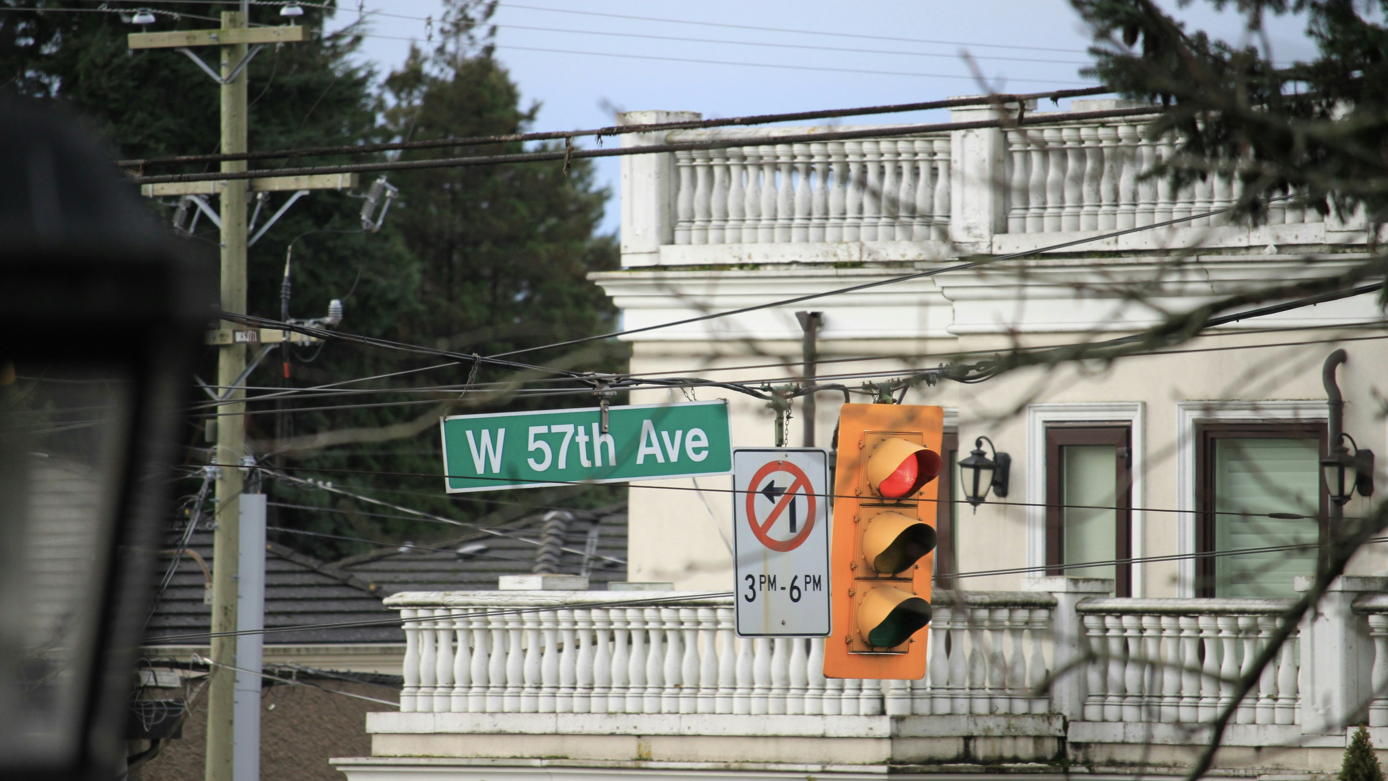 a traffic light and street sign in front of a house