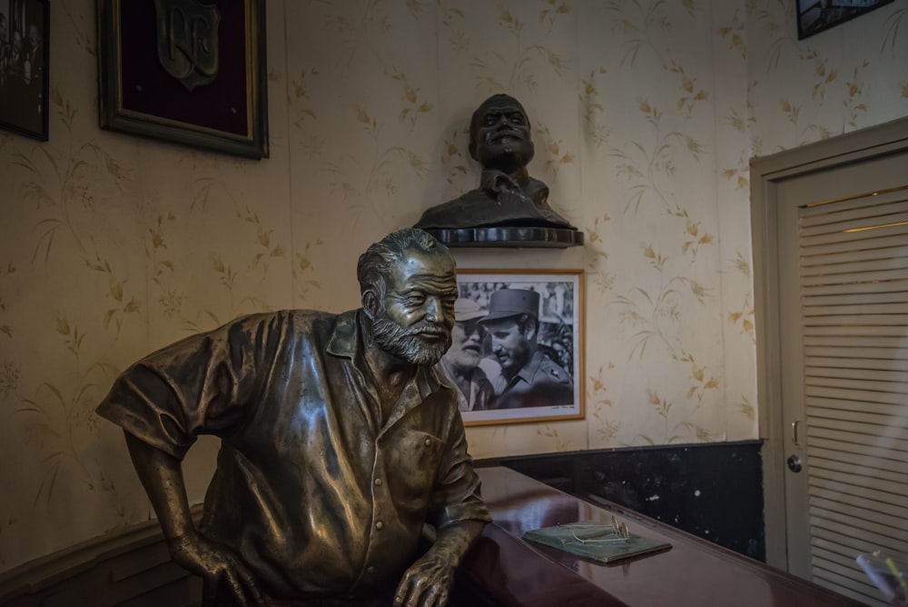 a bronze statue of a man sitting at a desk