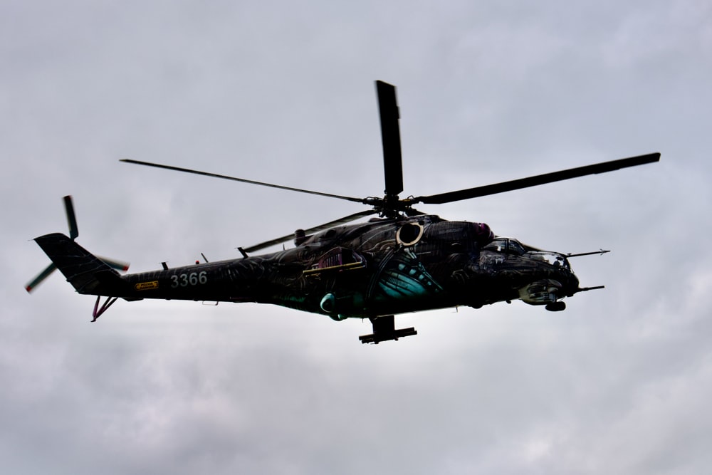 a helicopter flying through a cloudy sky