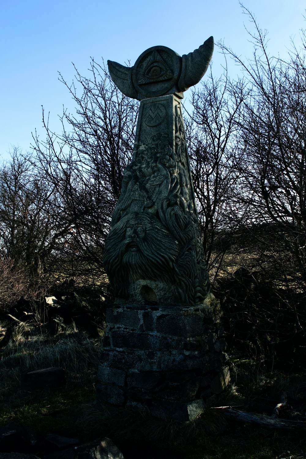 a statue of a bird in a grassy area