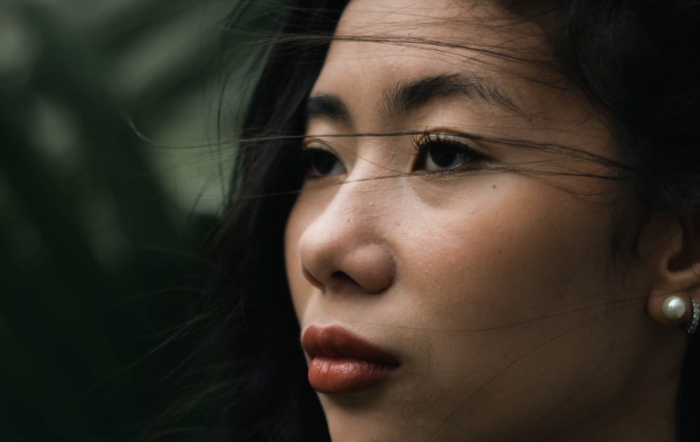 a close up of a woman wearing a necklace and earrings