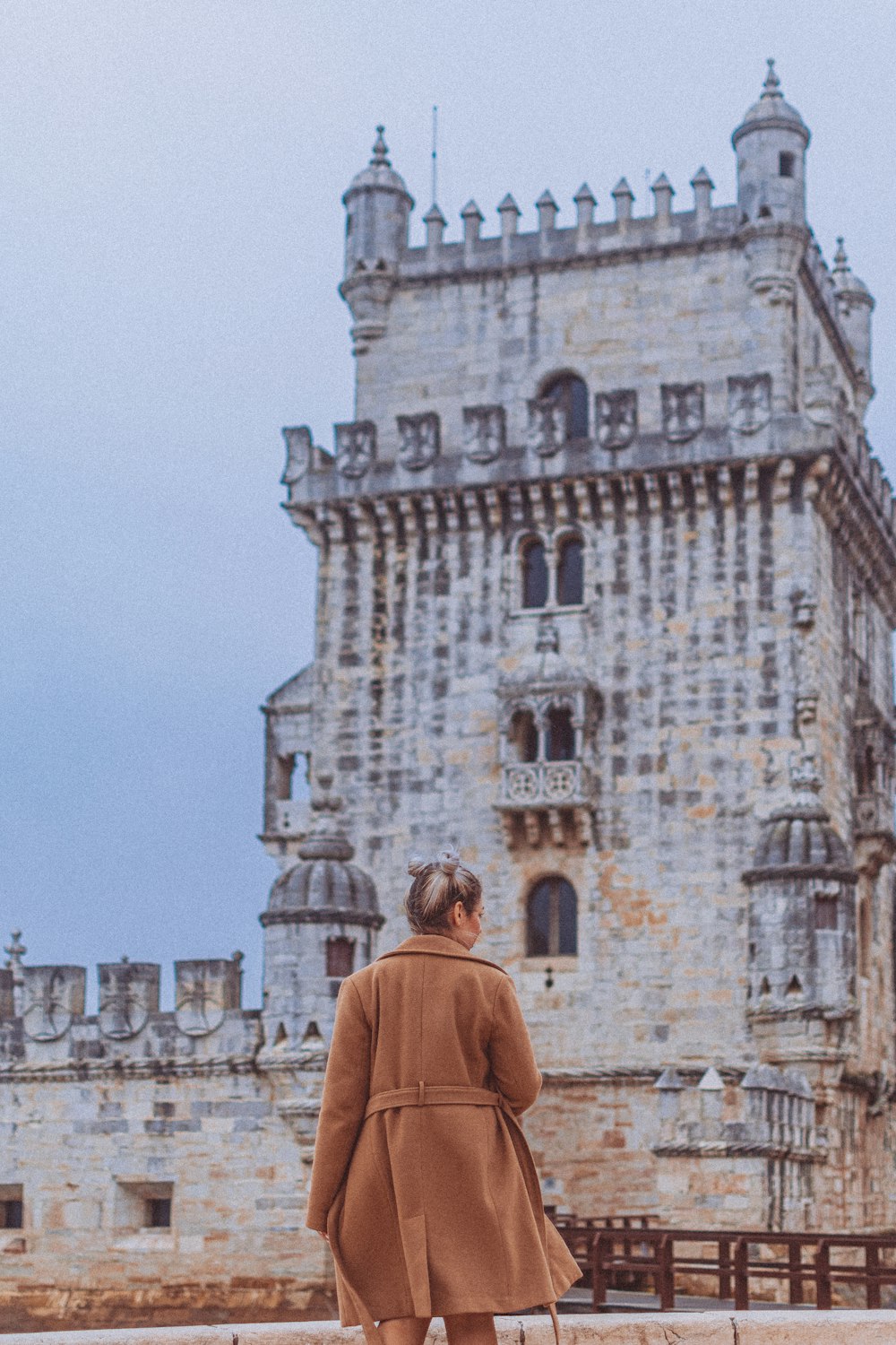 a woman standing in front of a castle