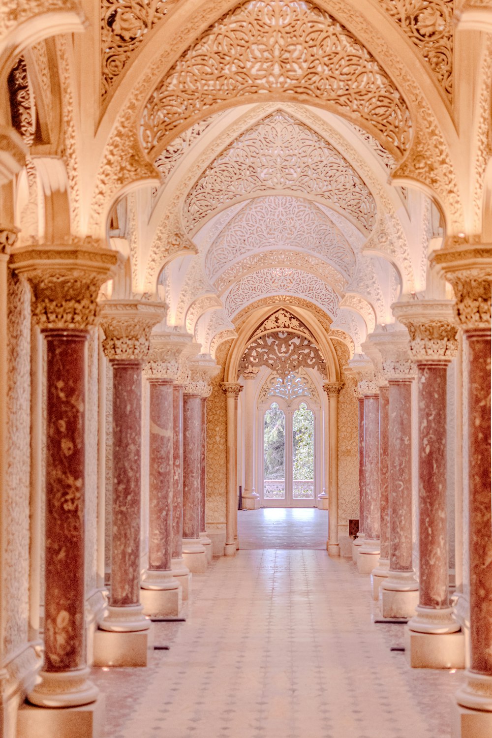 a long hallway with columns and a clock on the wall