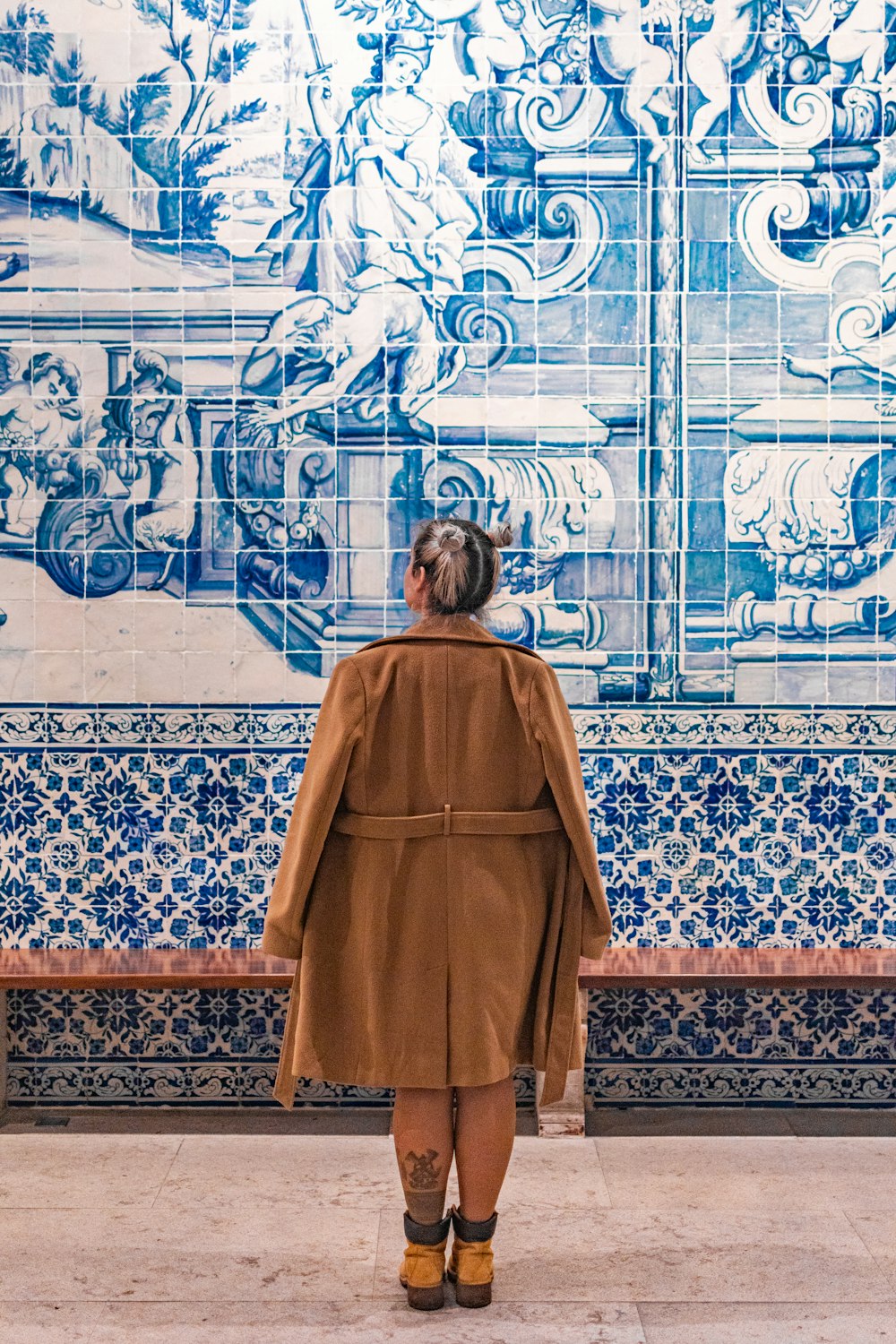 a woman standing in front of a blue and white wall