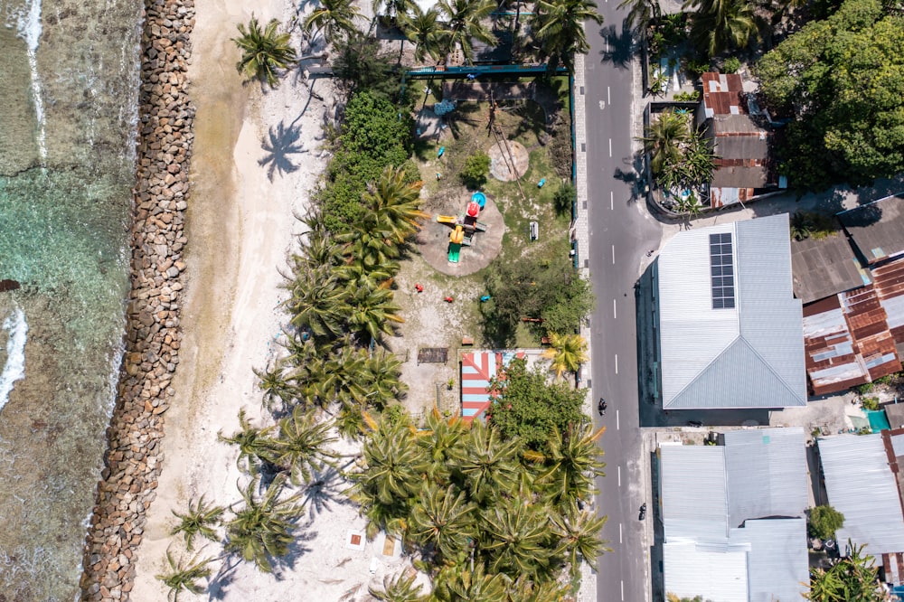 a bird's eye view of a beach with houses and palm trees