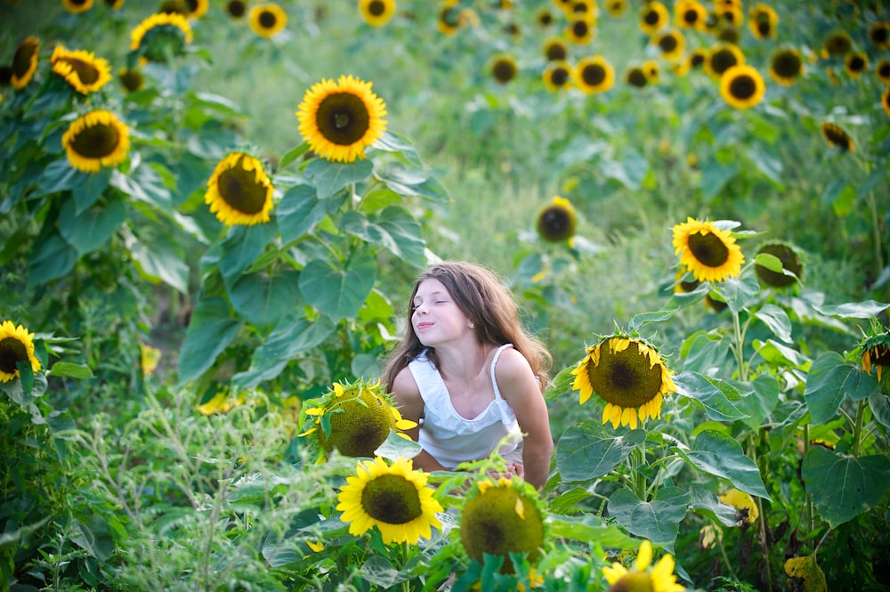a woman sitting in a field of sunflowers