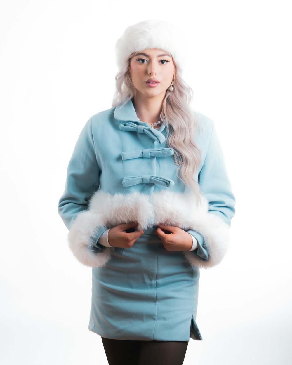 a woman wearing a blue coat and a white hat