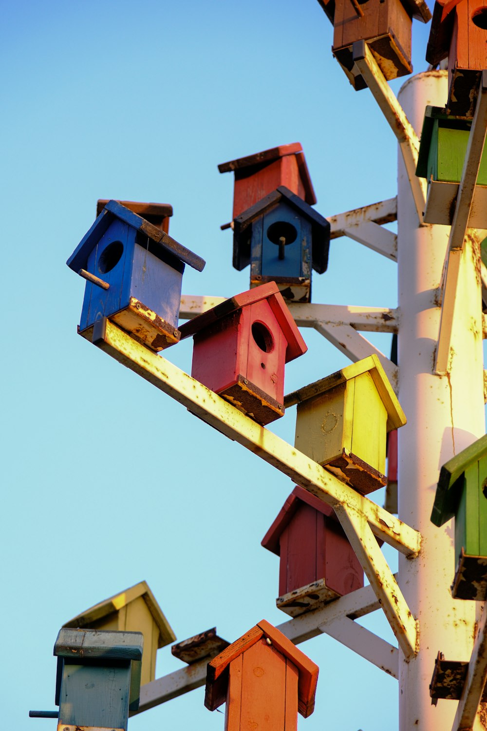 a bunch of colorful bird houses on a pole