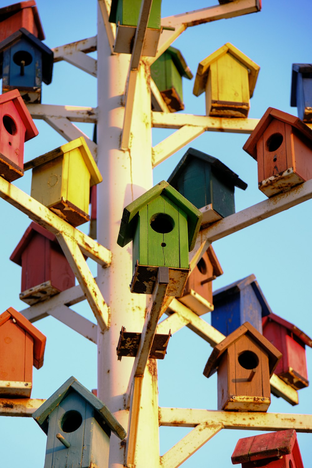 a bunch of colorful bird houses on a pole
