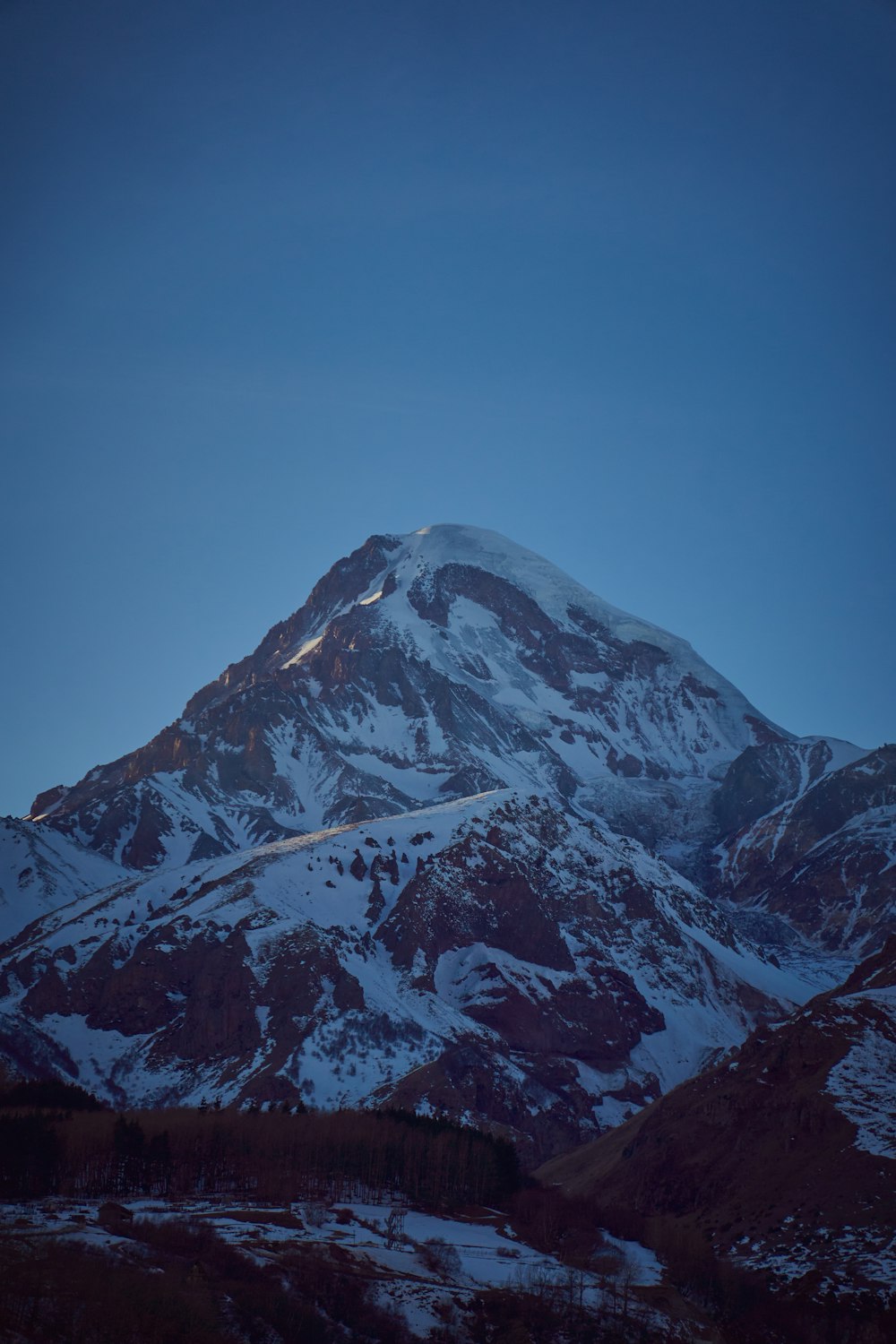 a mountain covered in snow under a blue sky