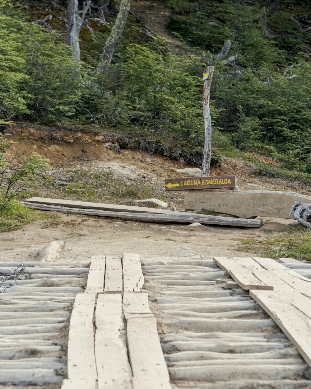 a pile of wooden boards sitting on top of a dirt road