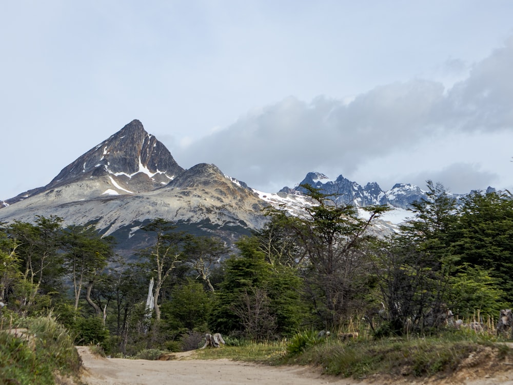 a dirt road with a mountain in the background