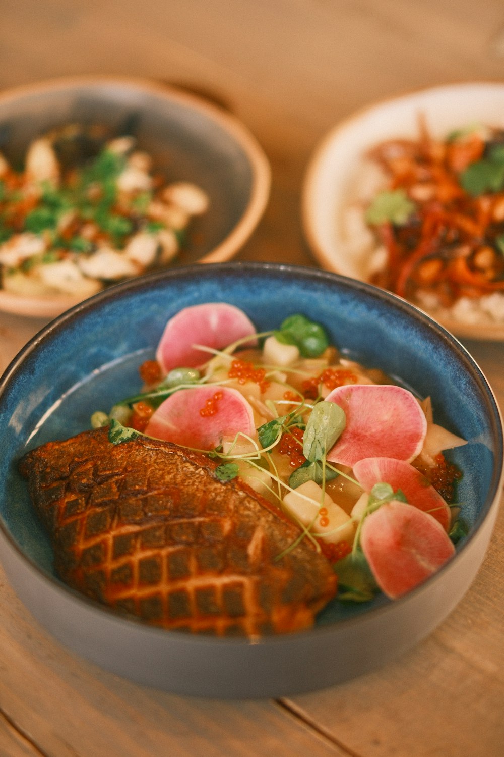 a blue bowl filled with food on top of a wooden table