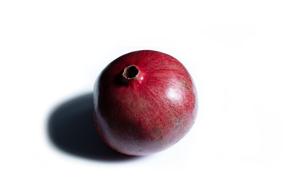 a red apple sitting on top of a white table