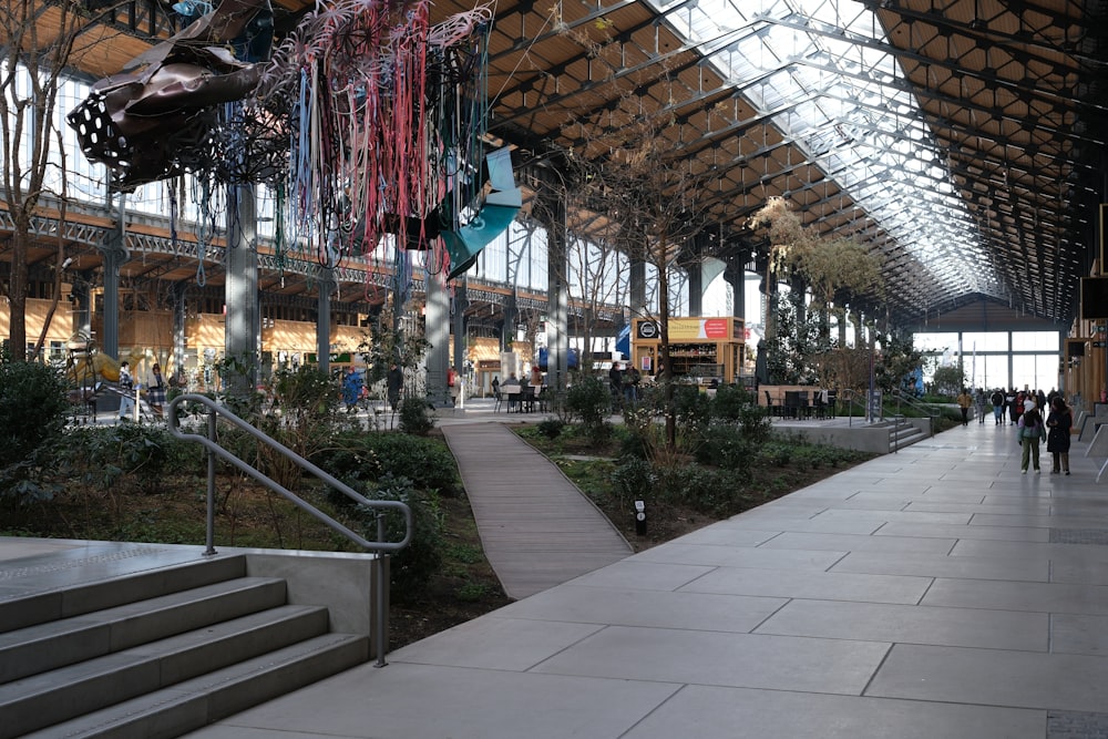 a walkway inside of a train station with people walking around