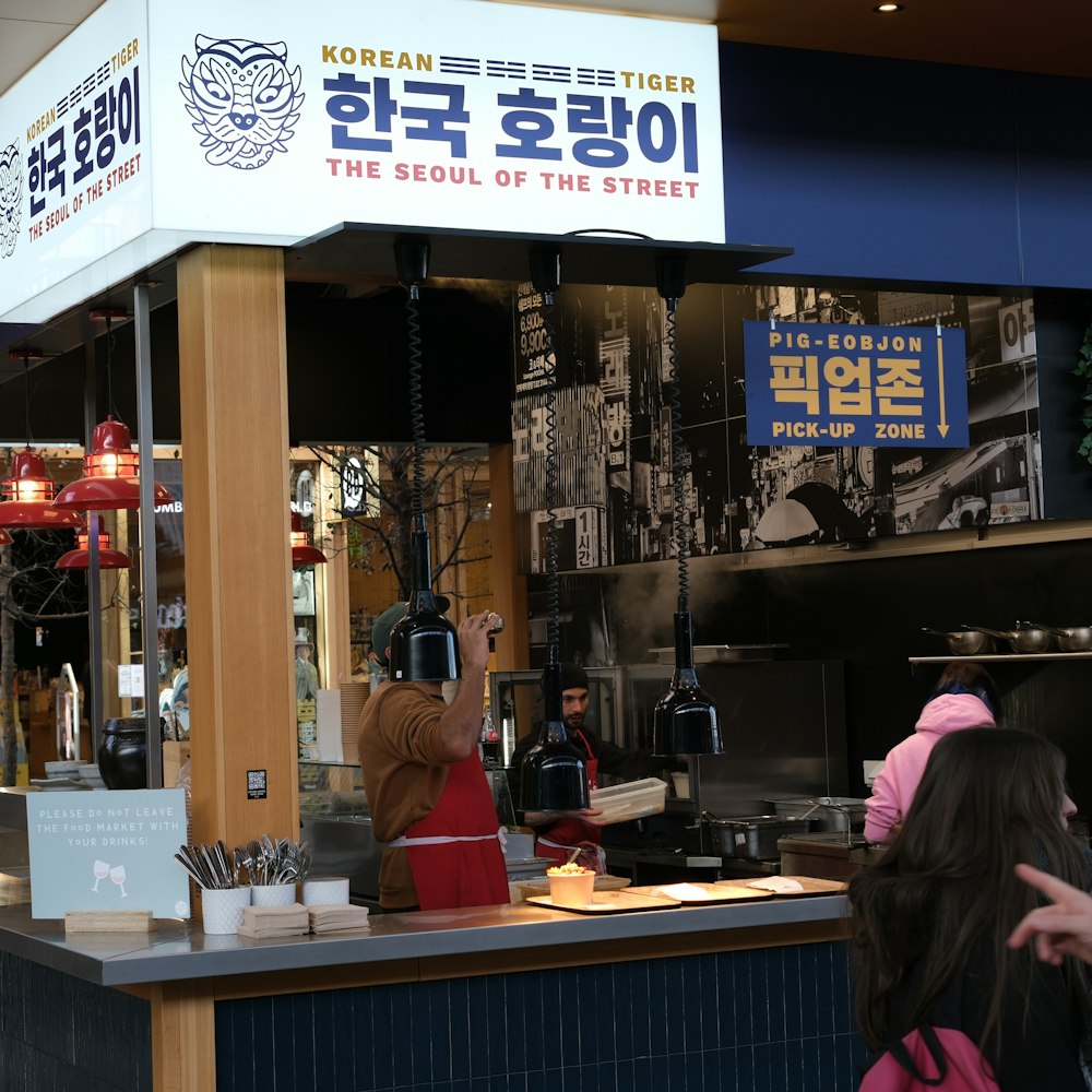 a person standing at a counter in a restaurant