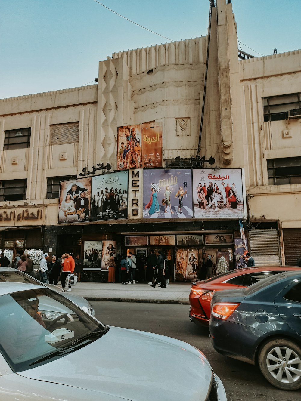 a movie theater with cars parked in front of it