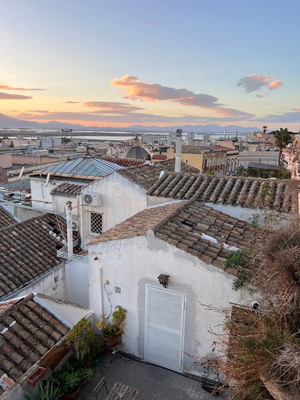 a view of rooftops and buildings with a sunset in the background