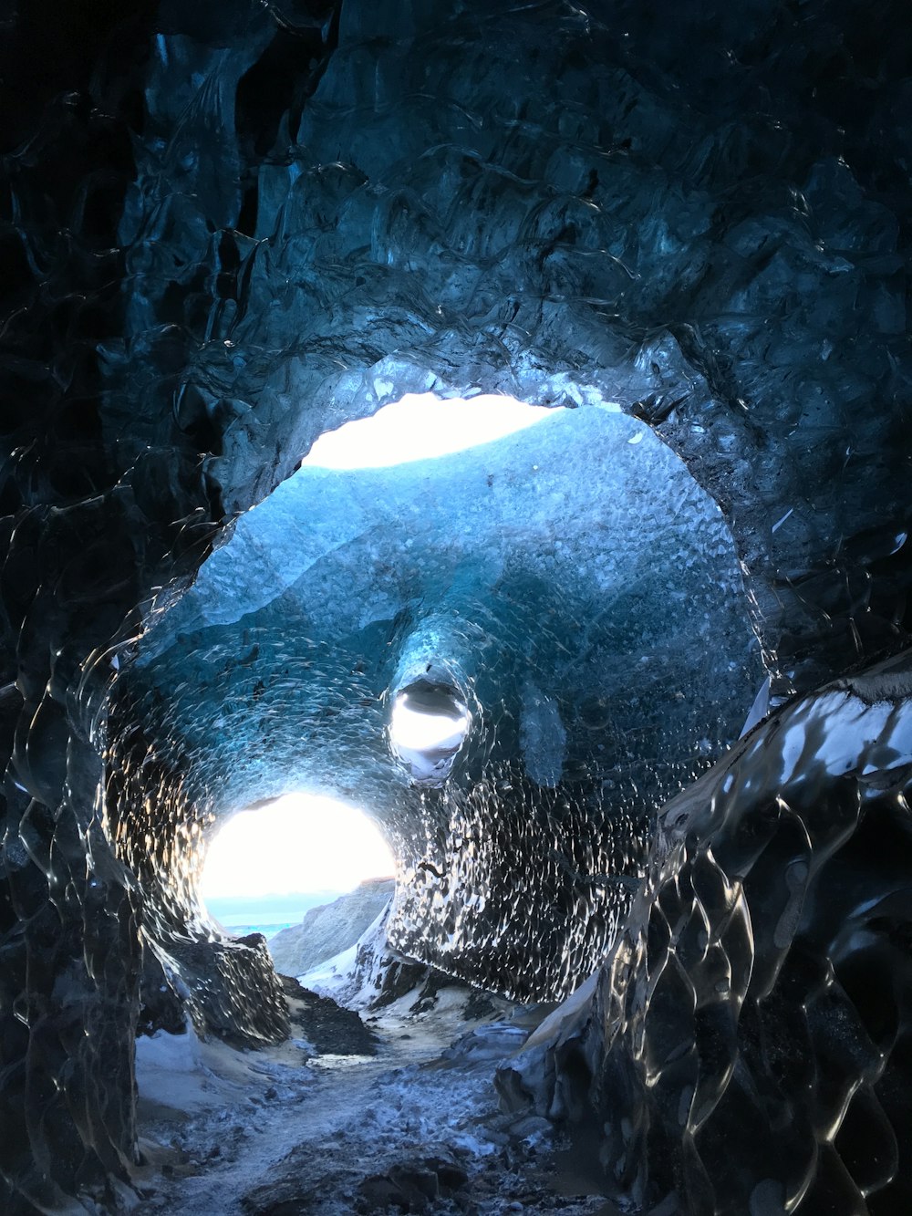 a large ice cave with a light at the end