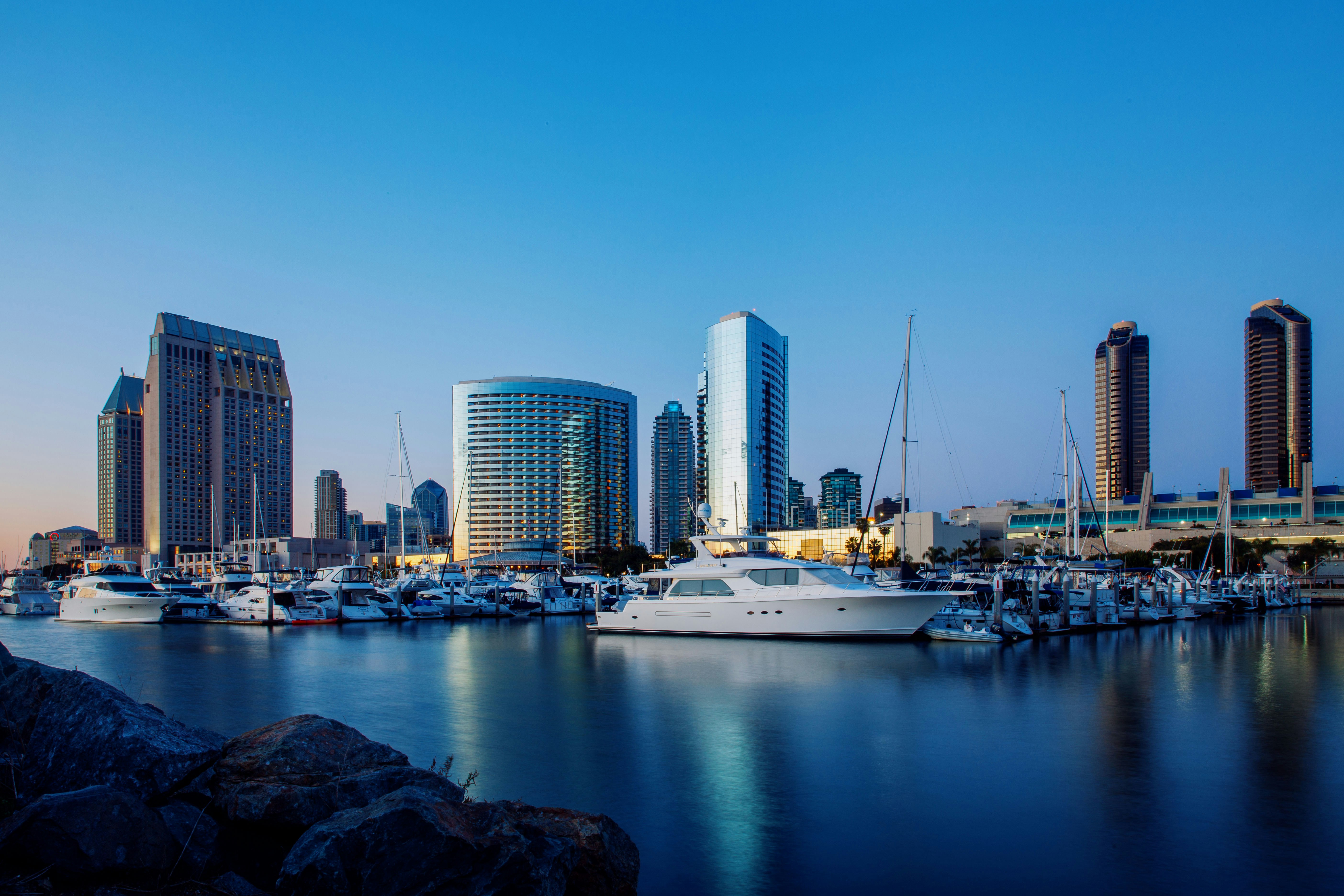 a harbor filled with lots of boats next to tall buildings