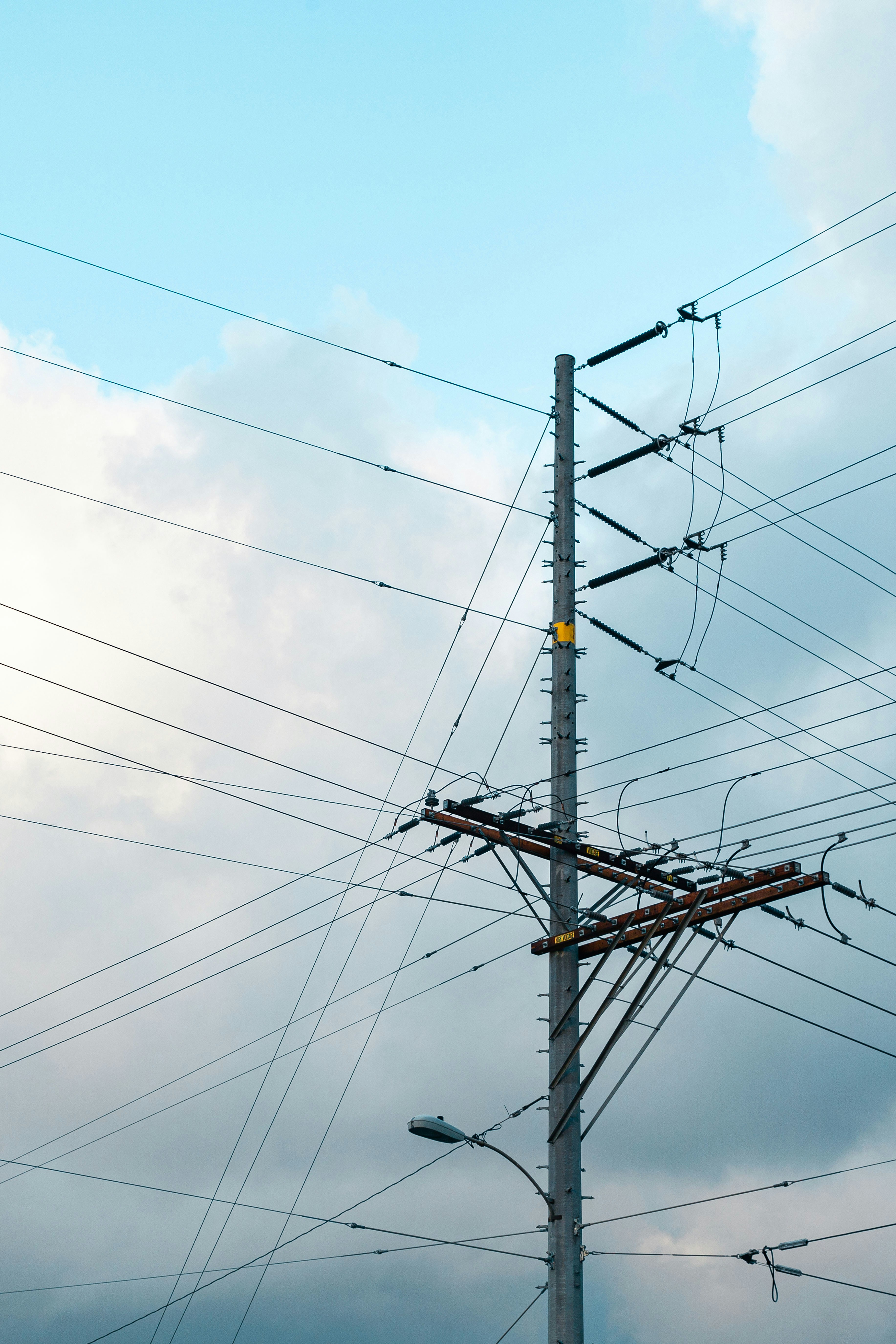 a pole with many wires and a traffic light on top of it