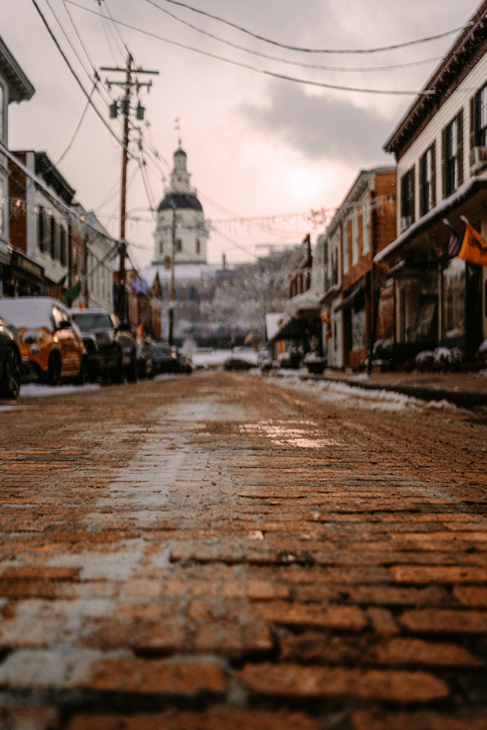 a brick street with a clock tower in the background