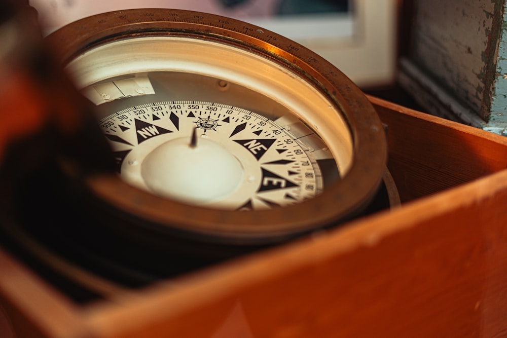 a close up of a compass in a wooden box