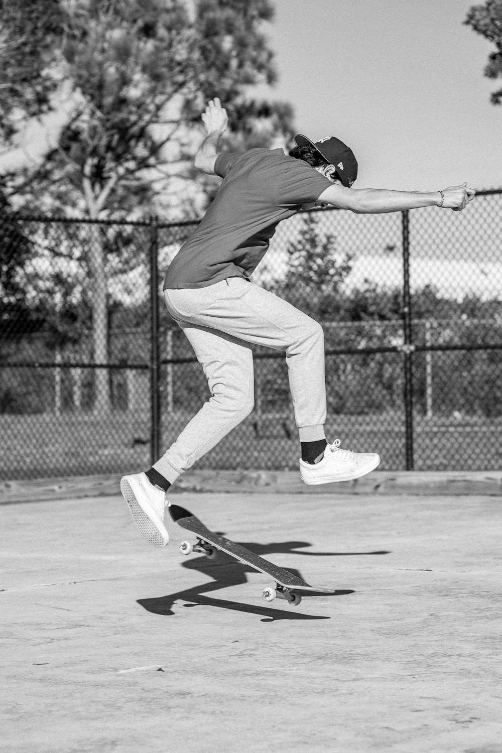 a man riding a skateboard on top of a tennis court