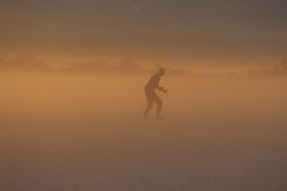 a man riding skis across a snow covered field