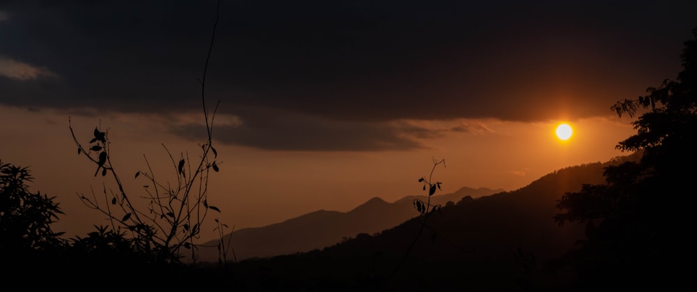 the sun is setting over a mountain range