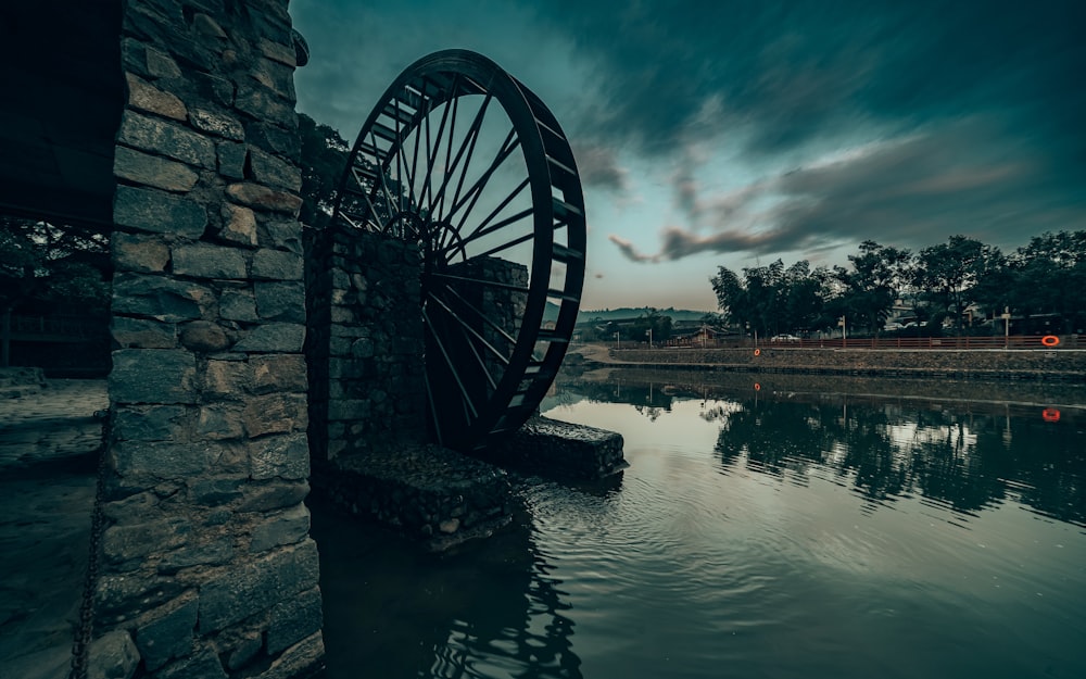 a water wheel sitting in the middle of a lake