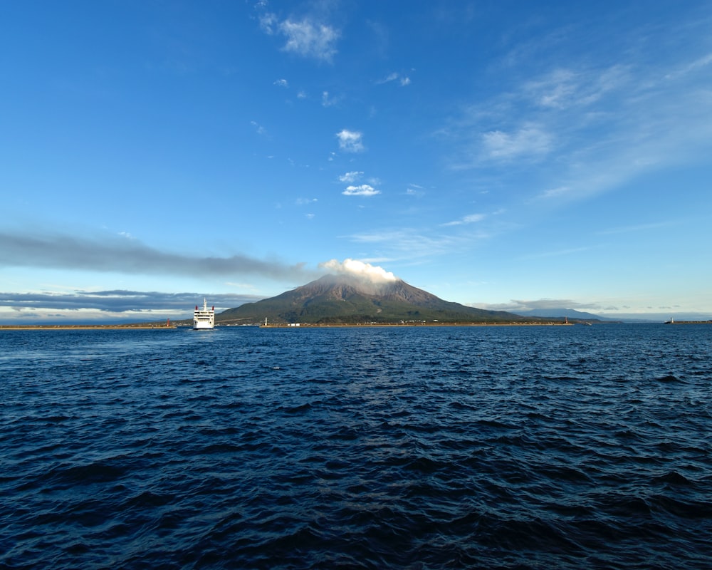 a large body of water with a mountain in the background