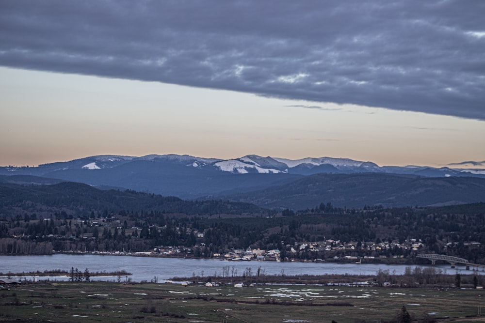 a view of a mountain range with a lake in the foreground