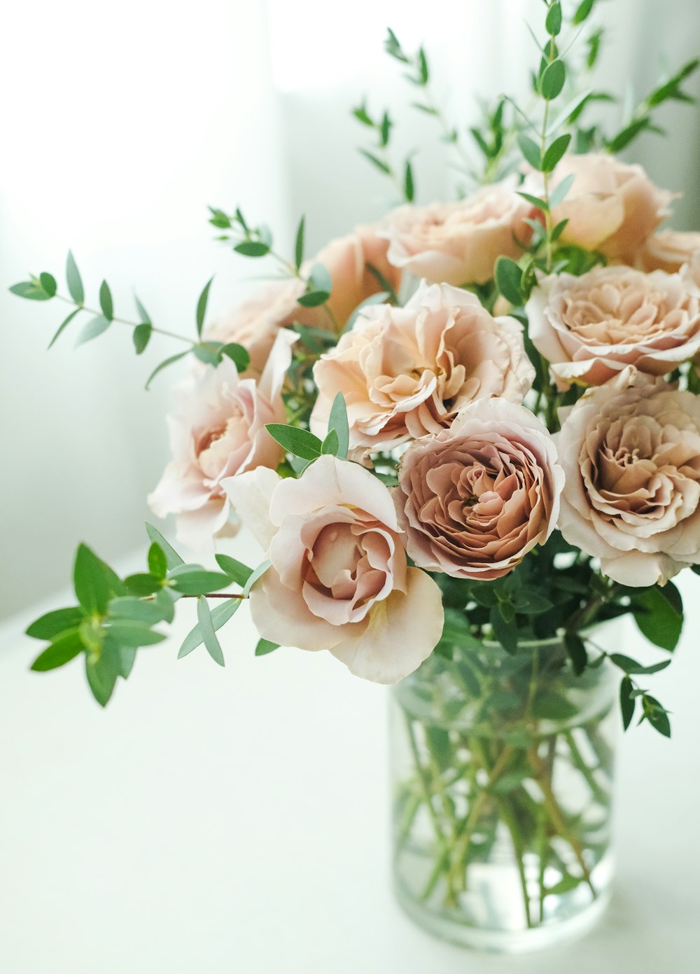 a vase filled with lots of pink flowers on top of a table