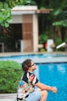 a man sitting on the edge of a swimming pool