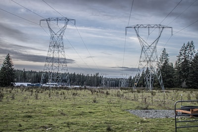 a field with power lines and a bench in the foreground